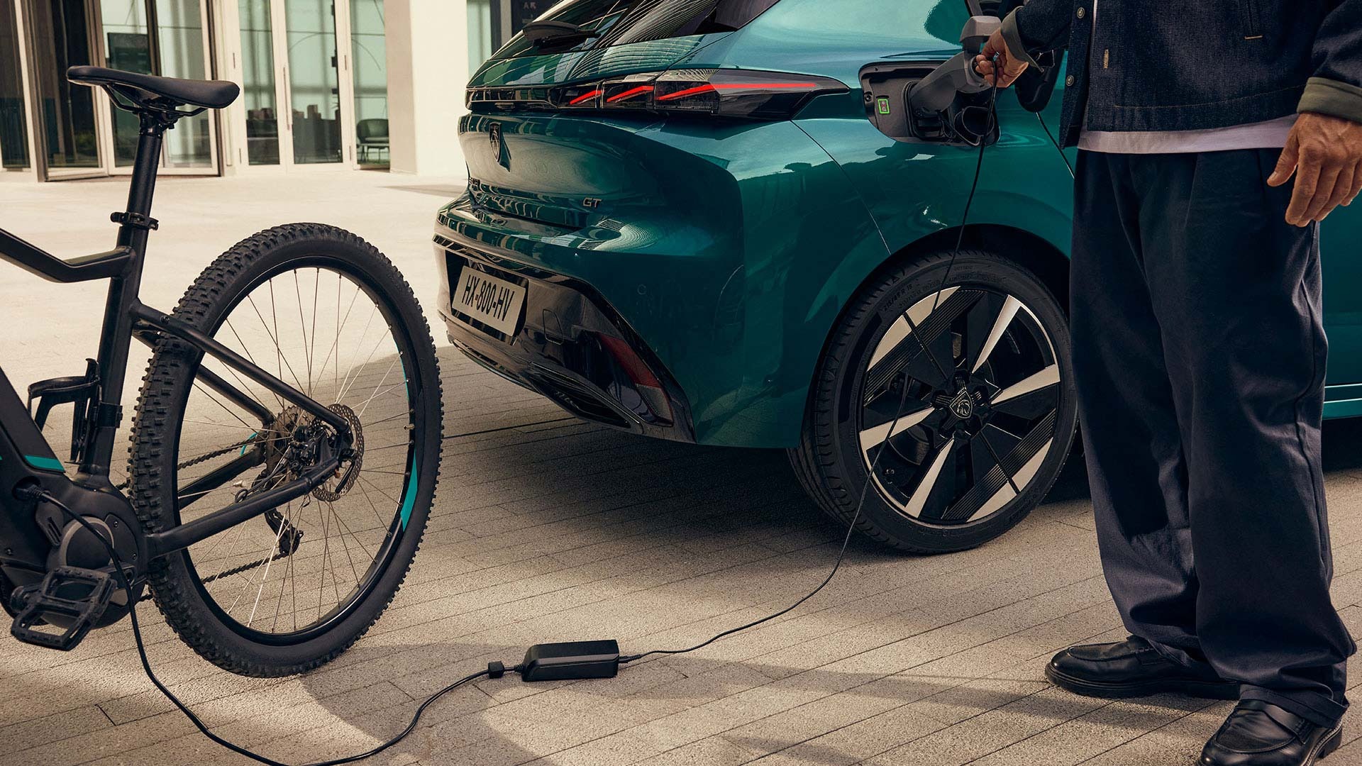 Electric bike plugged into a charging port of a car.