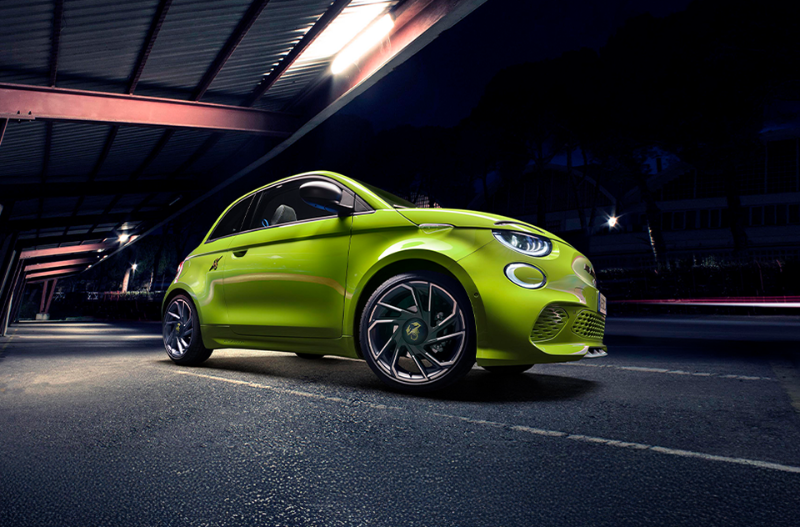 Bright green compact car parked at night under a lit shelter.