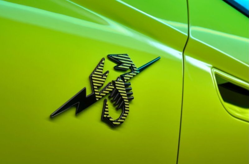 Car with a black and yellow striped badge on a bright green body.