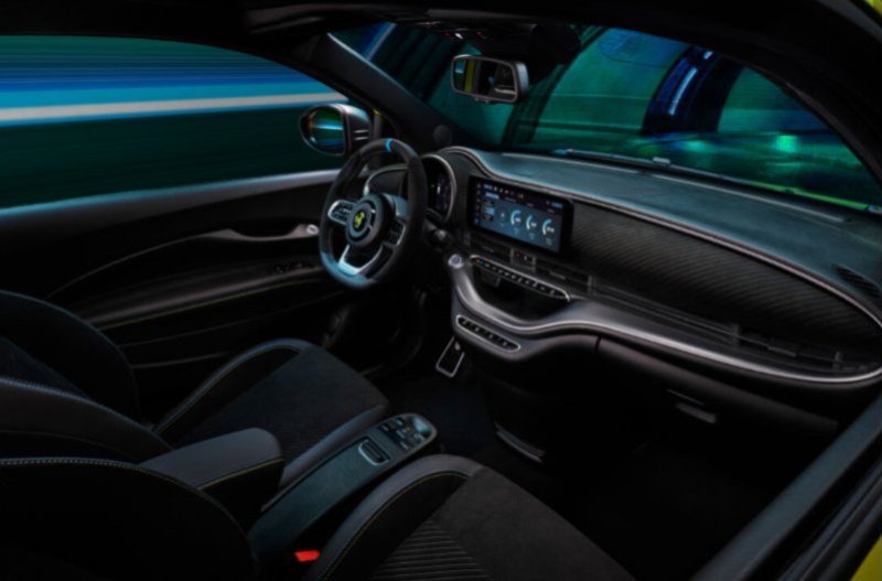 Car interior with black seats, steering wheel, digital display, and illuminated dashboard.
