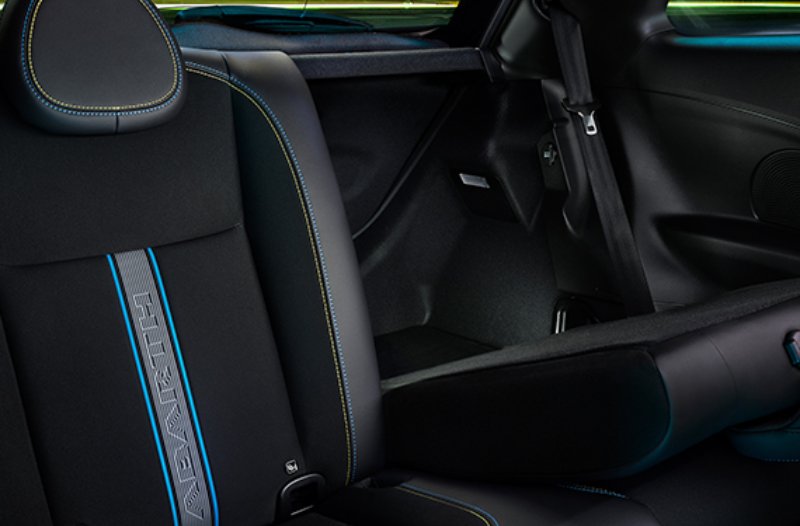 Car interior with black and blue seats featuring Abarth lettering on the backrest.