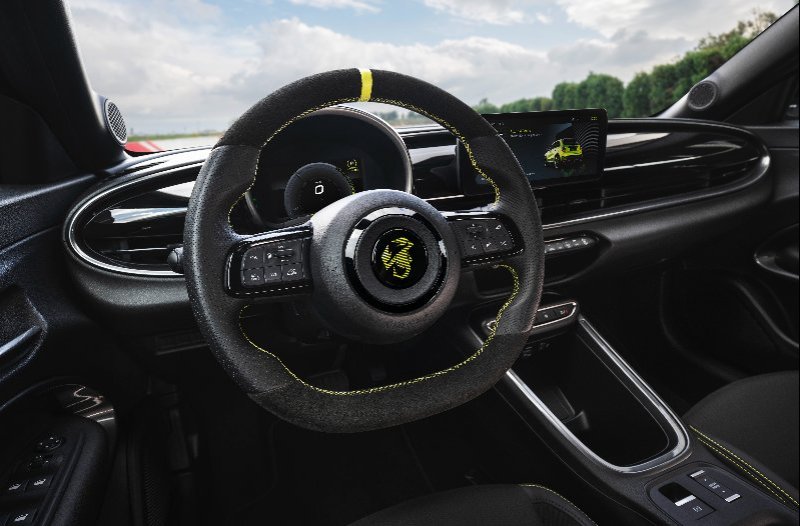 Steering wheel and dashboard of a modern car with yellow accents.