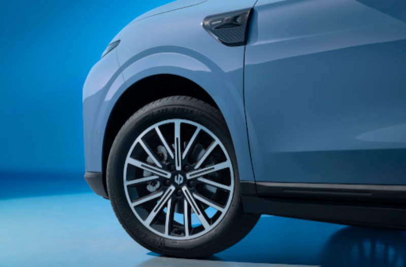 Close-up of a car's front wheel and fender in studio lighting.