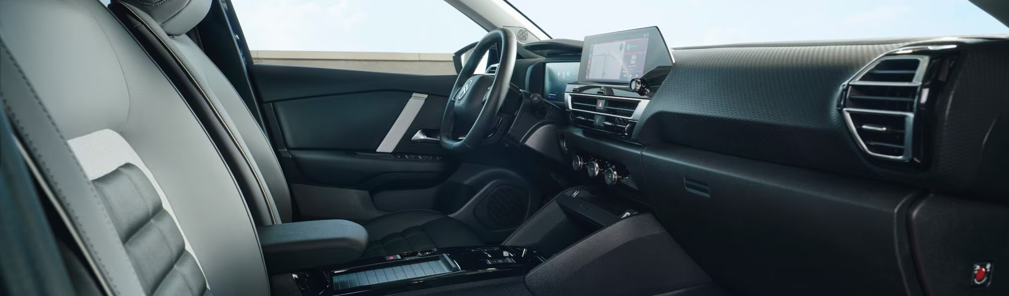 Interior of a modern car showing dashboard, steering wheel, and digital display screen.