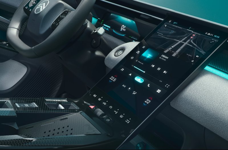 Car interior with steering wheel and touchscreen dashboard.