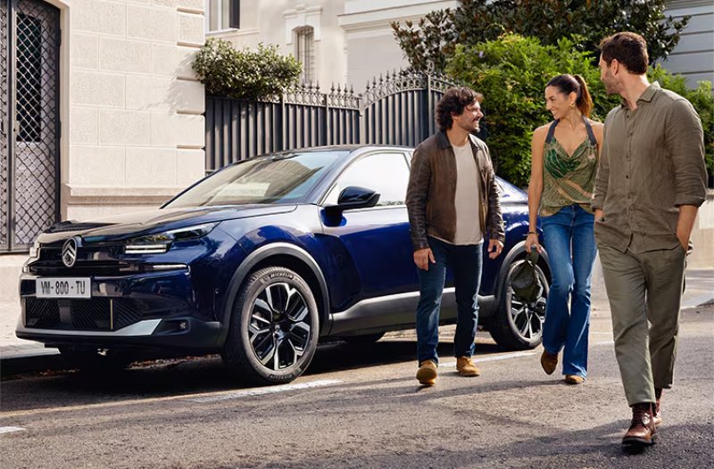 ciotroen c4 X in blue with people standing around