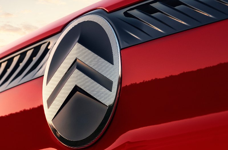 Close-up of a Citroën car badge on a red vehicle.