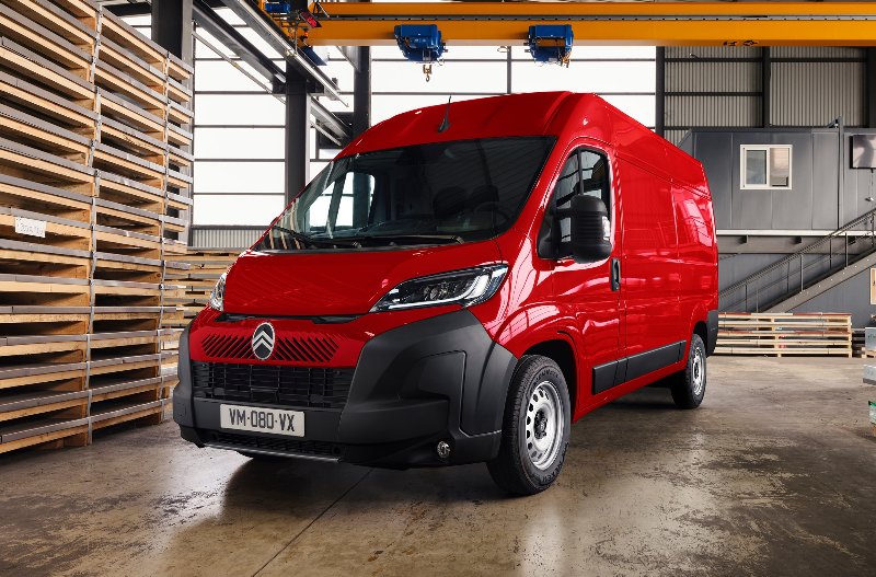 Red Citroën van parked indoors with pallets and metal beams nearby.