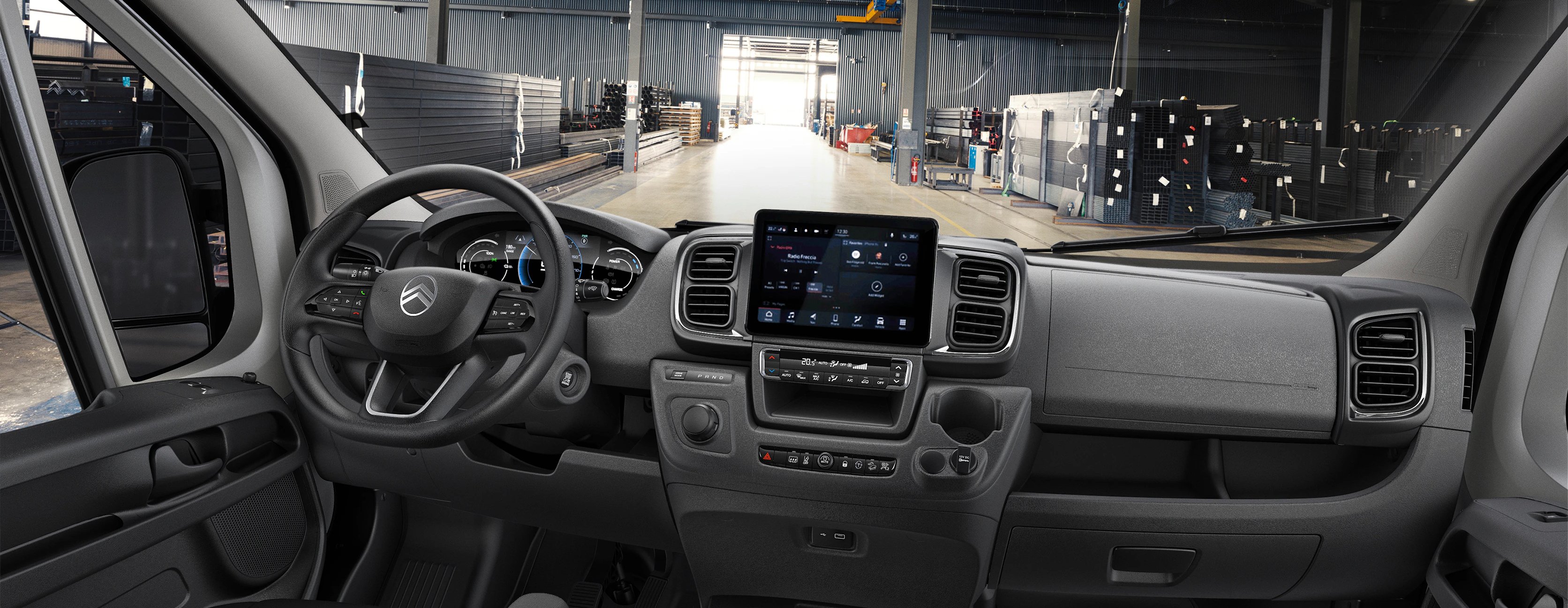 Interior of a van with steering wheel and digital dashboard display.