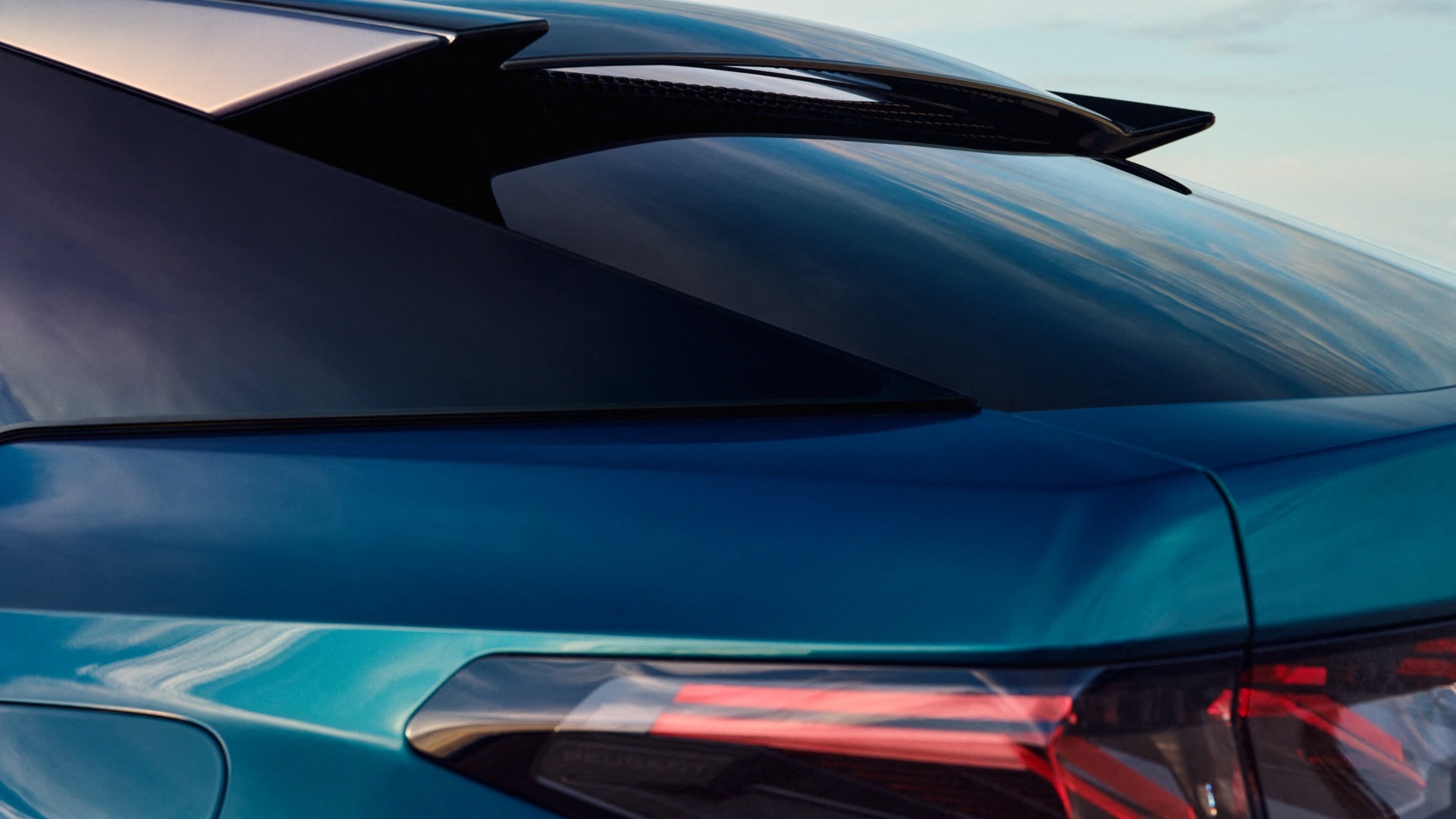 Close-up of a blue car's rear quarter, showing the window and back light detail.