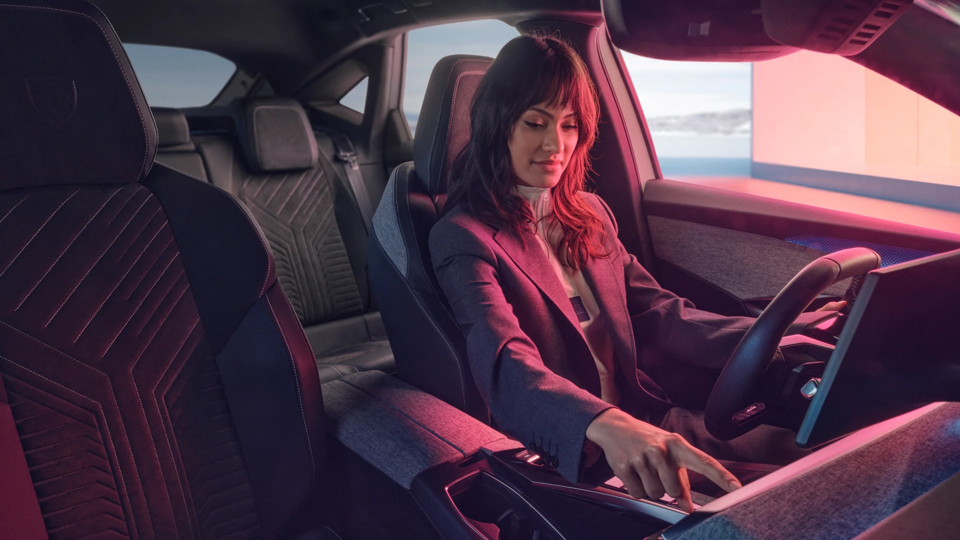 Woman in a car seat, pressing a control panel with a modern interior design.