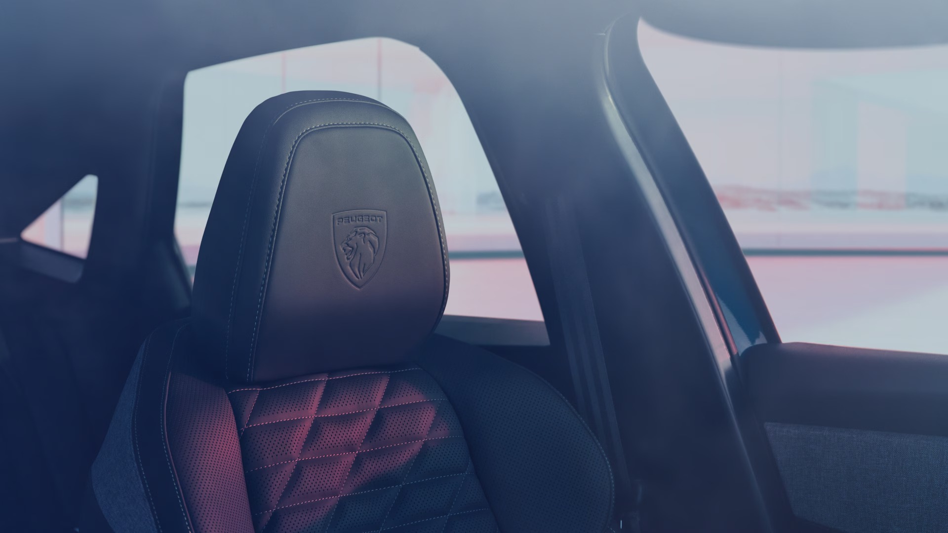 Car seat with Peugeot logo and quilted stitching.