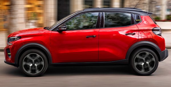 Red compact SUV driving on a city street.