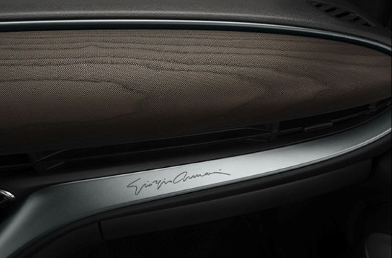 Car dashboard with a signature on a metallic panel.