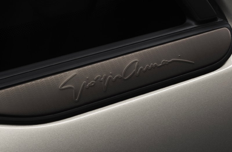 Car window close-up with Giorgio Armani logo.