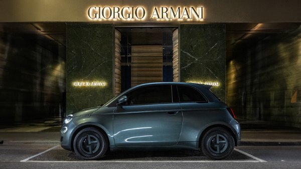 Compact grey car parked outside a Giorgio Armani store.