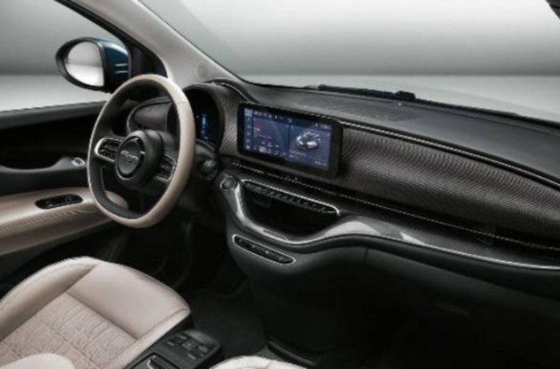 Car interior showing steering wheel, touchscreen display, and dashboard.