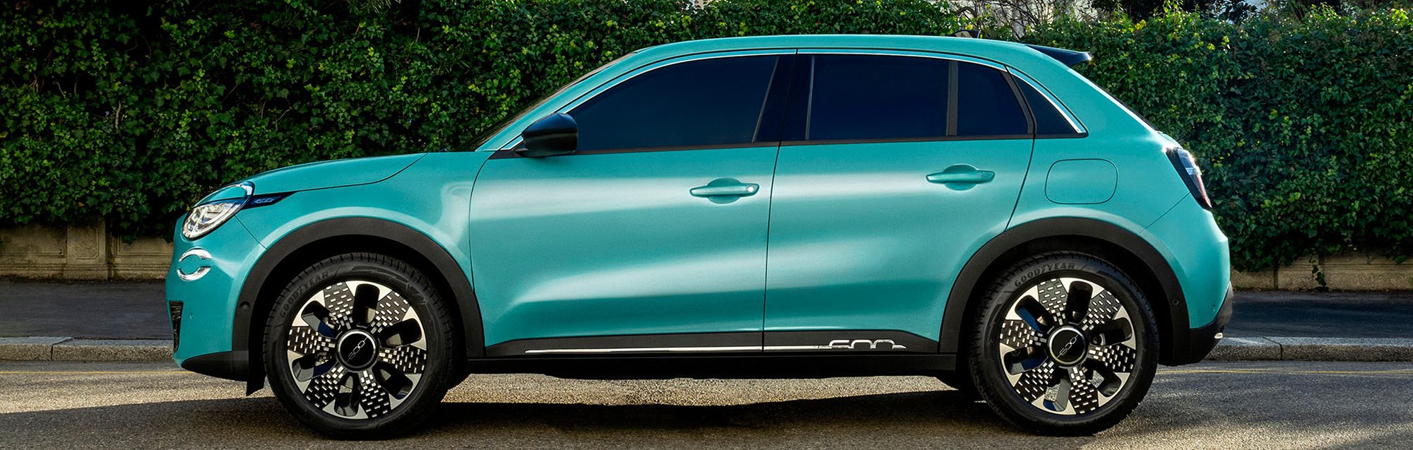 Side view of a teal compact SUV parked on the street.