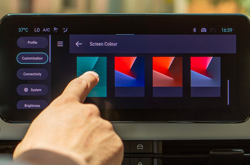 Finger selecting screen colour on a digital car display.