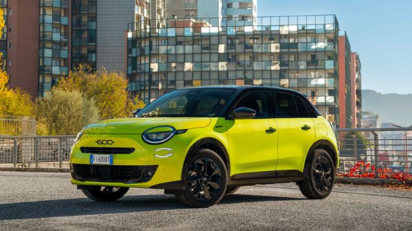 Neon green car in urban setting with buildings in the background.