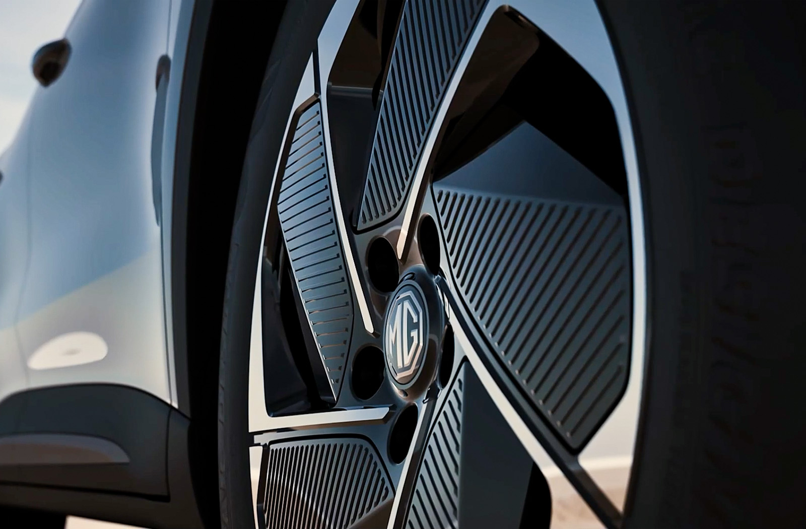 Close-up of a car wheel with an MG badge and a striped design.