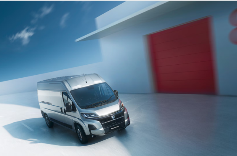 Silver van driving, large red door marked with number eight in the background.