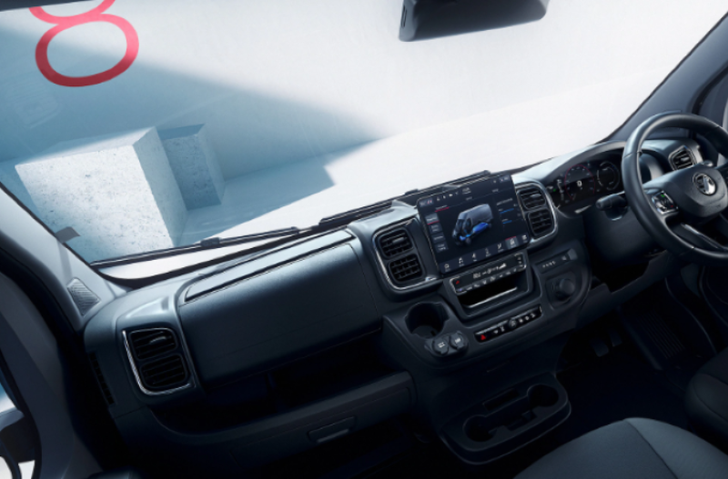 Interior view of a modern van with dashboard and steering wheel in focus.