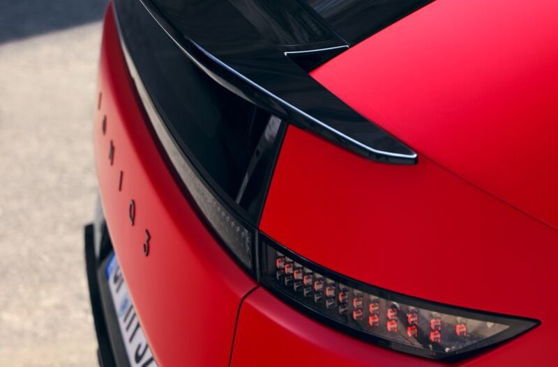 Red car with a black spoiler and detailed tail light.