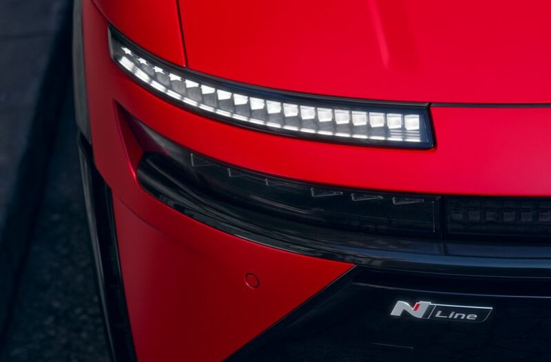 Close-up of a red car's front with LED lights and N Line badge.