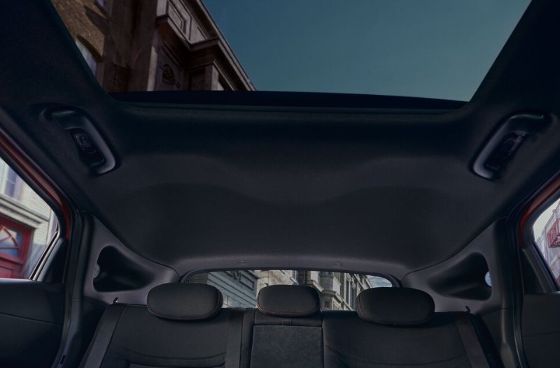 View of a car's back seats, rear windows and sunroof from inside.