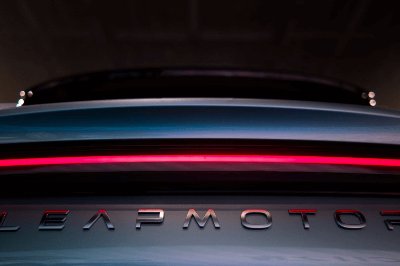 Close-up of a car badge with red light above the text LEAPMOTOR on the vehicle's rear.