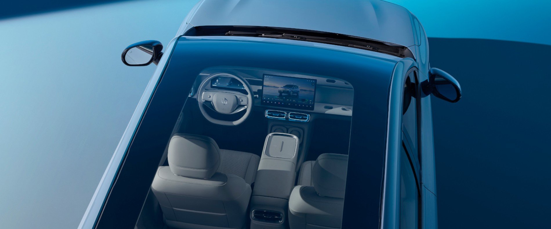 Overhead view of car interior through a transparent roof, showing seats and dashboard.