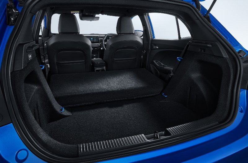 Car boot with seats folded down, showcasing interior space.
