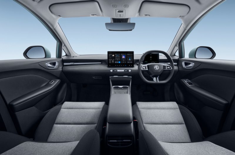 Interior of a car showing the dashboard, steering wheel, and two display screens.