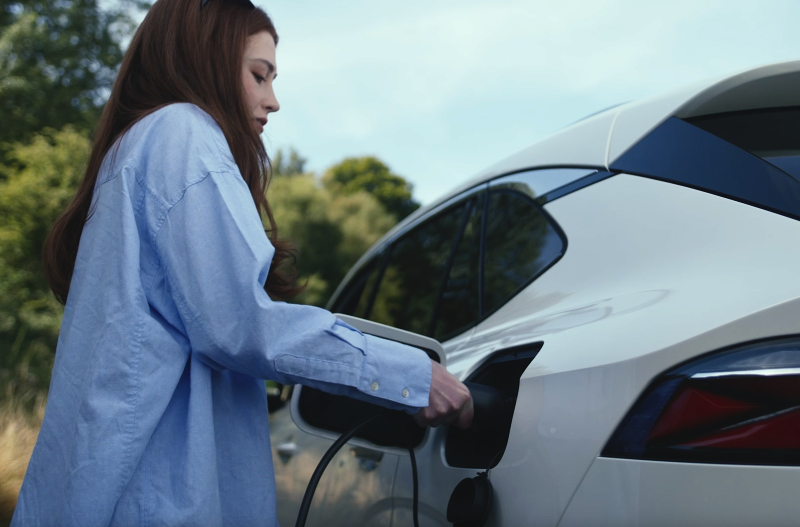 Person charging an electric car.