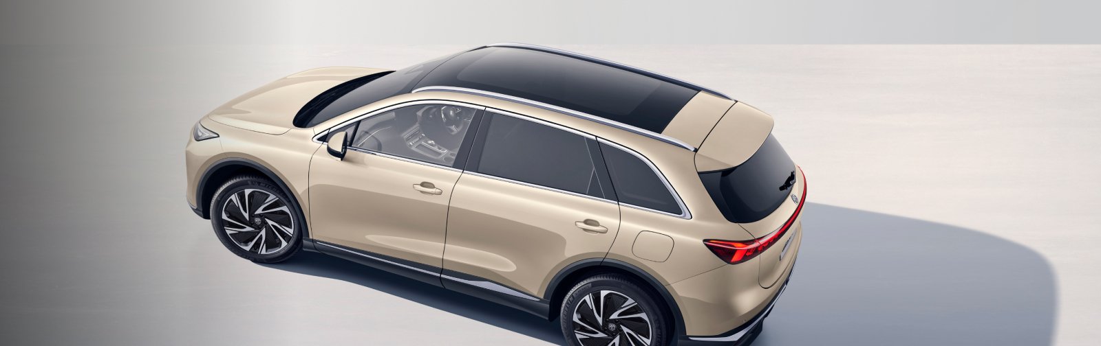 Overhead view of a beige SUV with a panoramic sunroof and alloy wheels.