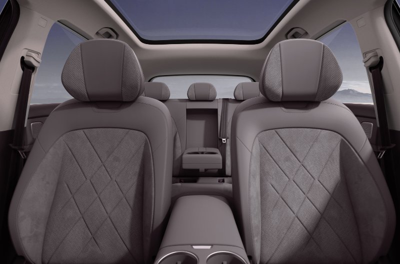 Car interior with two front seats, back seats, and a panoramic sunroof.
