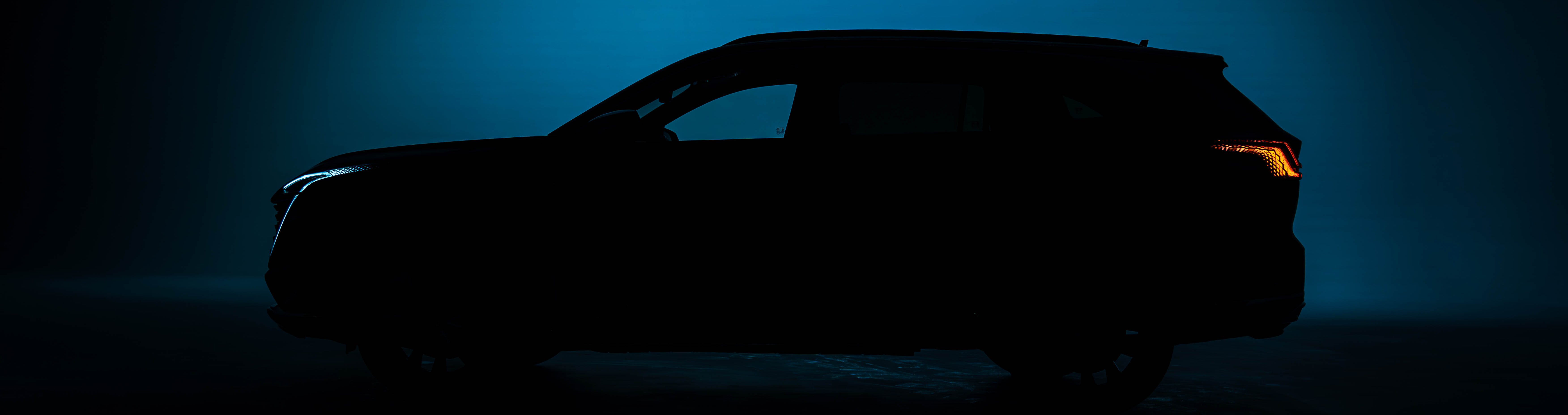 Silhouette of a car with illuminated headlights and tail lights against a dark background.