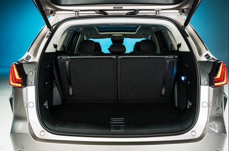 Open boot of a silver SUV showing folded rear seats and interior space.