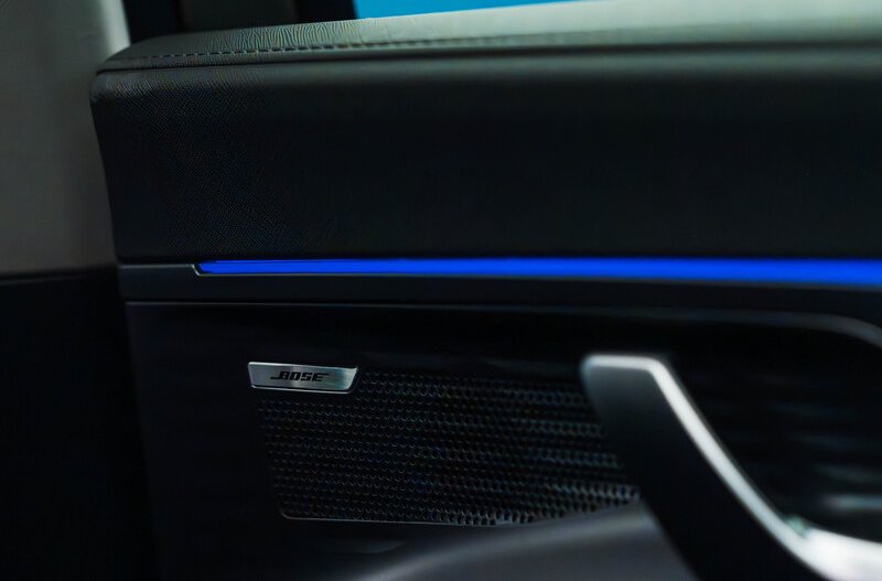 Close-up of a car door with a Bose speaker and a blue LED strip.