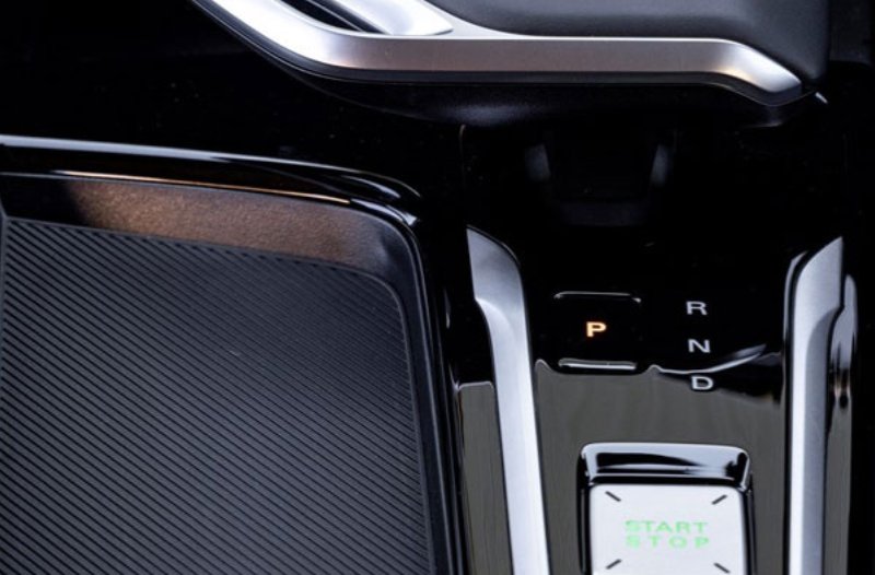 Close-up of a car's automatic gear selector and start/stop button.