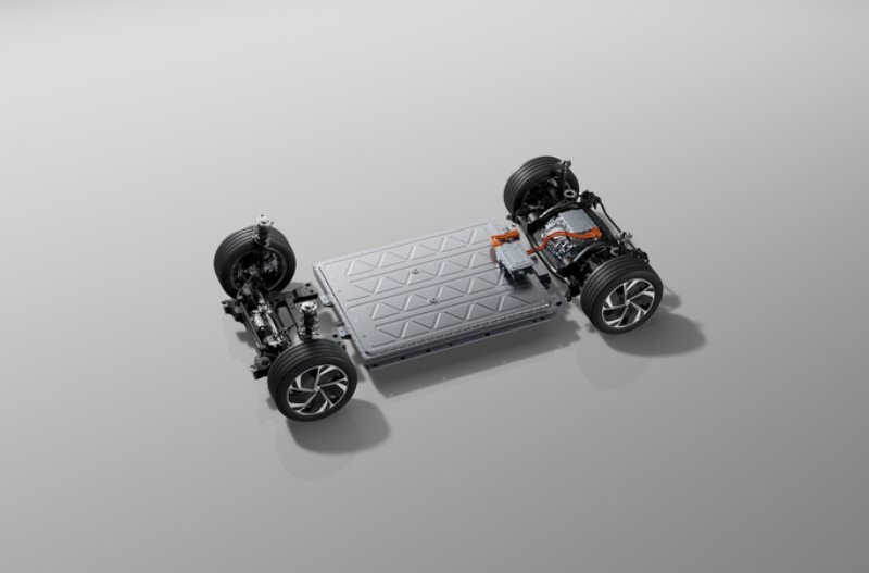 Electric vehicle chassis showing wheels, battery pack, and suspension components.