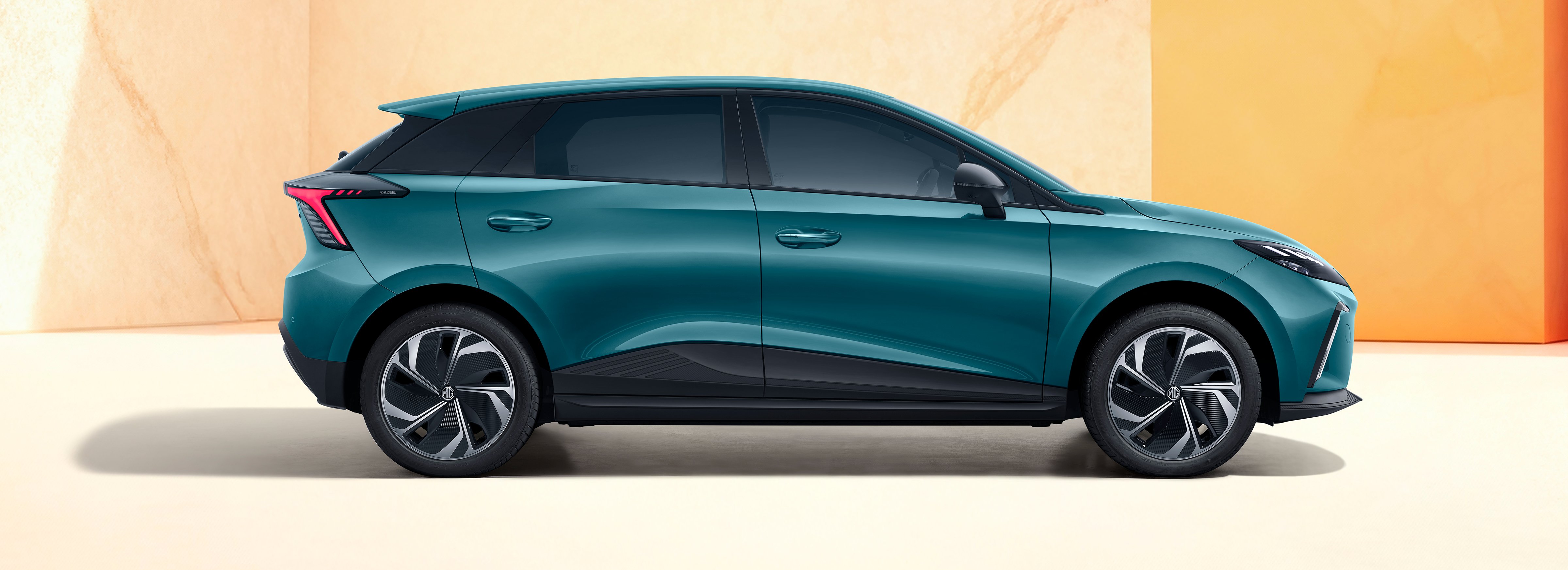 Side view of a teal hatchback car with modern design features.