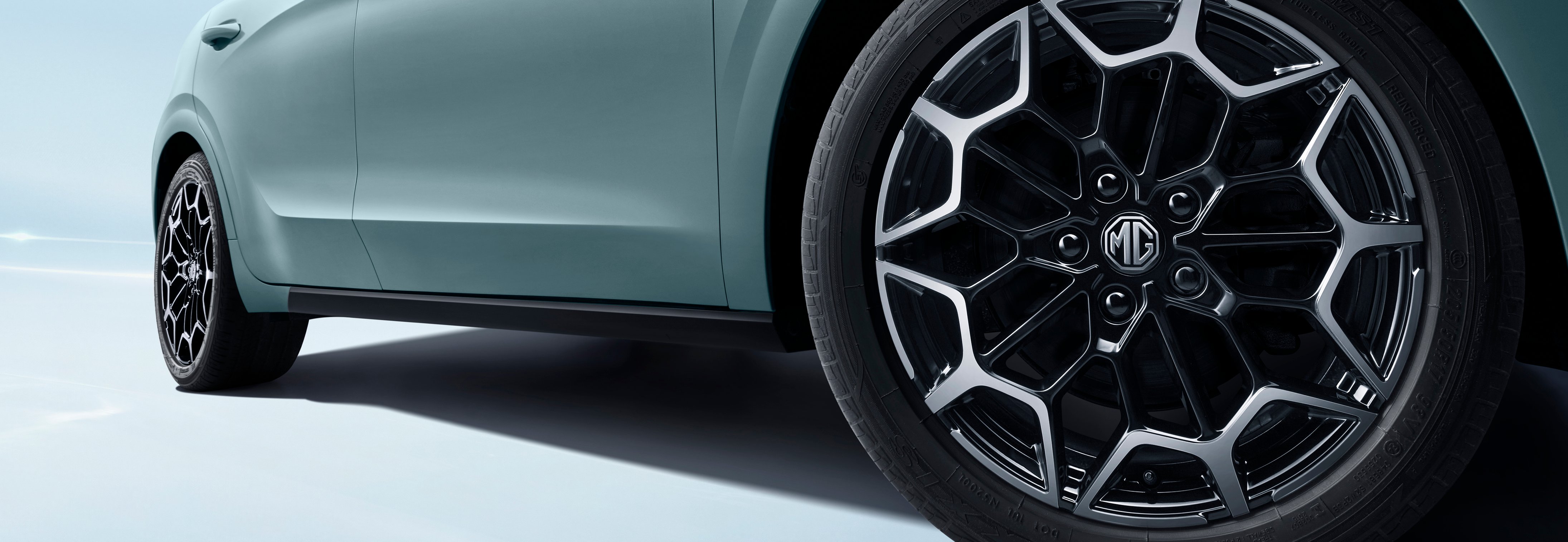Close-up of metallic car wheel and tyre with MG logo.