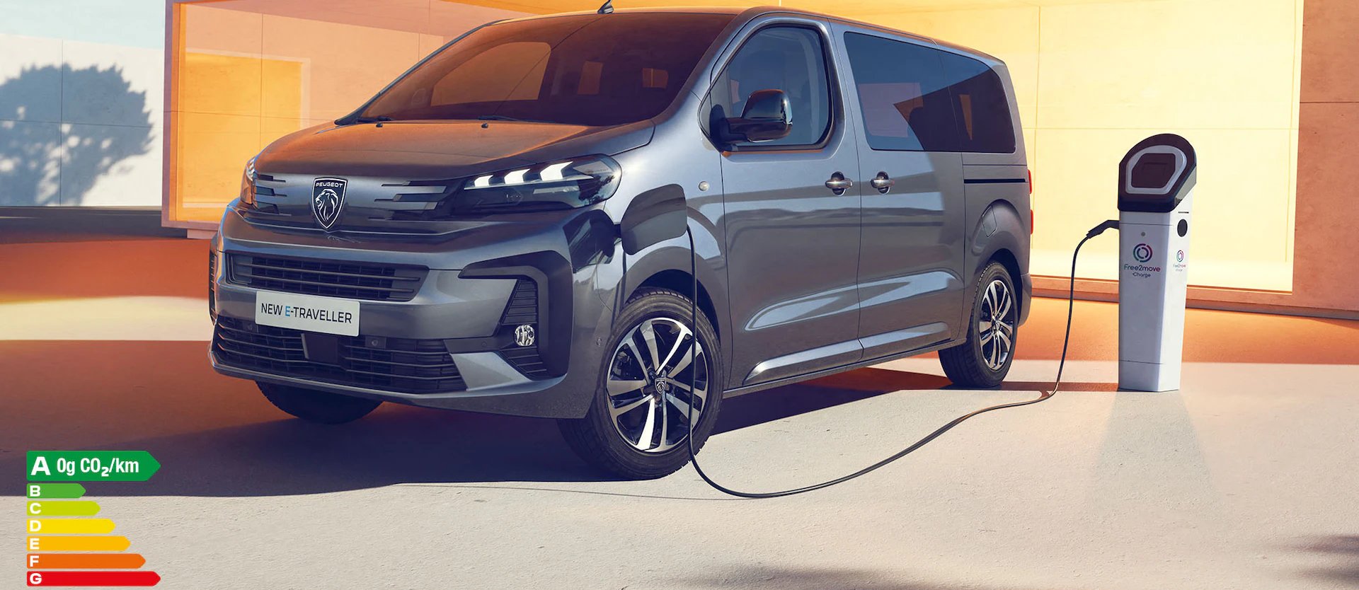 Electric van charging at a charging station, labelled New E-Traveller.