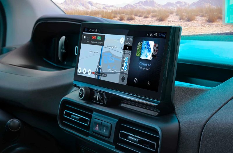 Car dashboard with touchscreen displaying navigation and music controls.