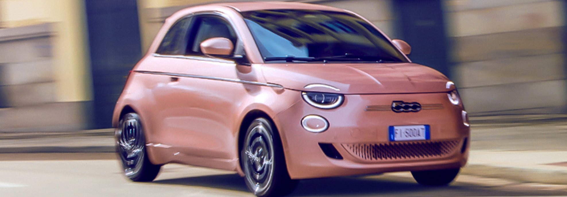 Pink compact car driving on a street.