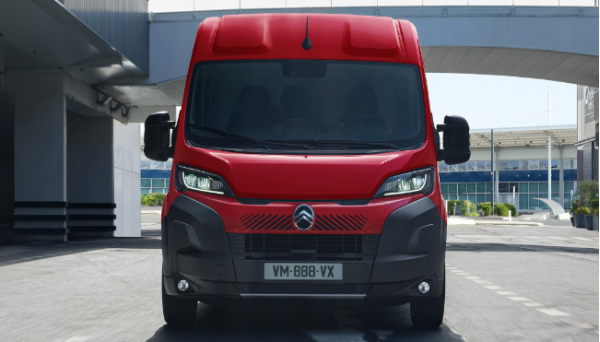 Red Citroën van viewed from the front on a city street.
