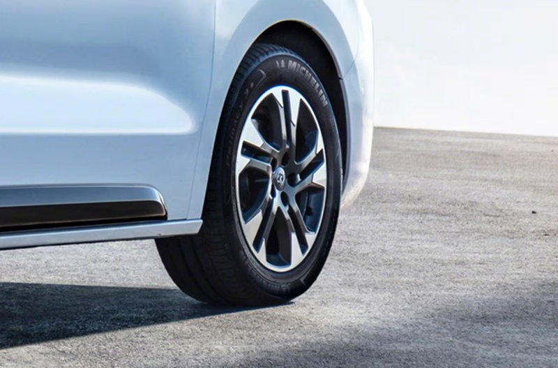 Close-up of a white car’s rear tyre and alloy wheel.