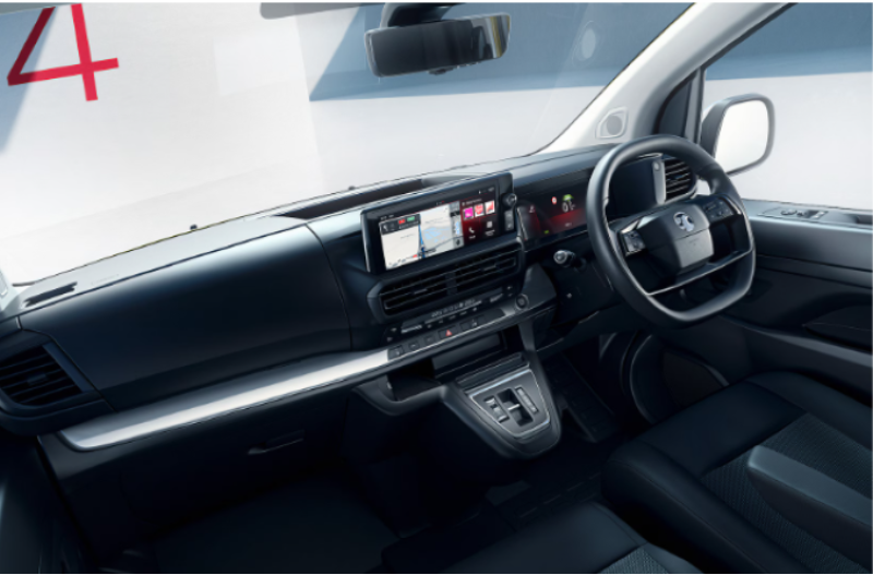 Interior view of a vehicle dashboard featuring a touchscreen display and steering wheel.